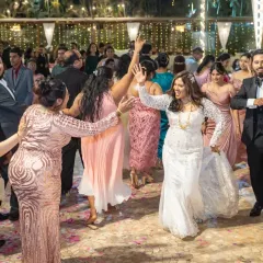 Let's get the party started! I'm right there on the dance floor with you, capturing the energy and joy of the celebration. This shot shows the groom and guests joining the bride for a fun, candid reception moment.
