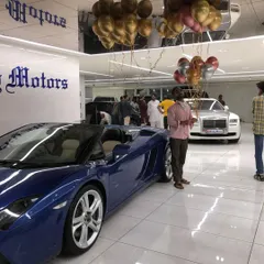 A wide shot of the Lucky Motors showroom during their anniversary event. The ceiling is filled with metallic helium balloons, creating a festive atmosphere throughout the entire space for guests and staff to enjoy.