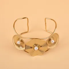 A statement gold-tone floral cuff bracelet, shot on a clean, neutral background to emphasize its design.