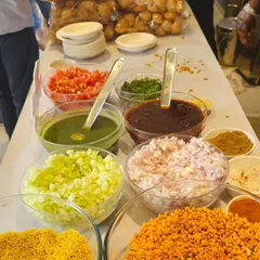 Our Bhel Puri station shows puffed rice, sev, chopped onions, tomatoes and chutneys arranged together for the live chaat counter.
