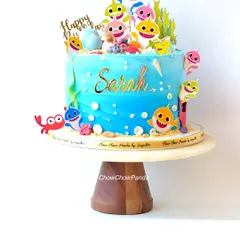 A fun and colourful Baby Shark cake, perfect for a toddler's birthday. This Black Forest cake is decorated with the whole shark family, edible bubbles, and seaweed details to create an underwater scene.