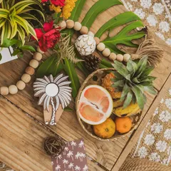 A tabletop detail with fresh tropical fruits, wooden beads, and custom stationery, reflecting the natural and local elements of the island.