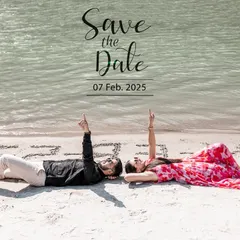 A creative "Save the Date" shot with the couple lying on the sand, pointing up to the text. This is a fun and personal way to announce your wedding date.