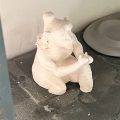 The Hanuman sculpture after its first firing (bisque firing). At this stage, the clay has turned white and is hard but still porous, ready for glazing or final touches.