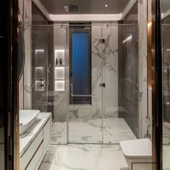 A frontal view of the same bathroom, showcasing the clean lines of the floating vanity and the seamless glass shower door. The design feels spacious, modern, and impeccably detailed.