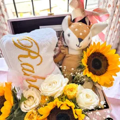 Another angle of the 'Raha' hamper, showing the arrangement of the personalized towel, plush toy, and fresh sunflowers in a pink keepsake box.