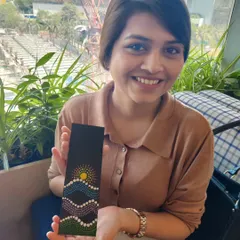 A close-up of a participant from the corporate workshop, delighted with her finished piece. The dot art bookmark features a unique design, showing how a simple activity can lead to a personalized and satisfying outcome.