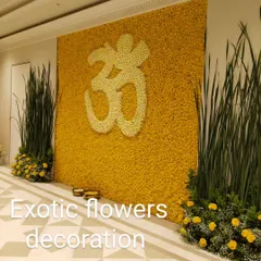We create spiritual symbols with flowers. This stunning wall features the 'Om' symbol meticulously crafted from white flowers against a backdrop of thousands of yellow marigolds.