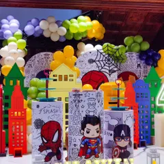 A close-up of the superhero squad. The custom-printed plinths featuring Spider-Man, Superman, and Captain America are perfect for displaying the cake and desserts, tying the whole theme together.