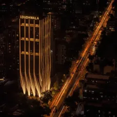 The illuminated facade of ID Origins in Mumbai creates a powerful visual statement at night. The undulating calligraphic strokes are highlighted, transforming the building into a beacon and a landmark for the surrounding 12-acre site.
