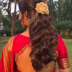 A back view of the half-updo, showing the lush curls and the beautiful jasmine and chain accessory.