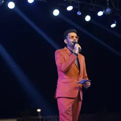 Under the spotlight at a sangeet night. I weave a story of joy and celebration with every word, making the event as vibrant and beautiful as the occasion itself.