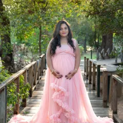 Our soft pink ruffled gown is perfect for a romantic and gentle look, seen here on a wooden bridge in a park.