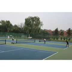 An overview of the tennis facility at Modern School, with several courts in use. The green surroundings and well-kept grounds provide a pleasant atmosphere for competitive play.
