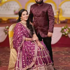 Another elegant portrait of the engaged couple. The bride is seated while her partner stands beside her, creating a timeless and well-composed photograph.