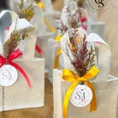 Simple, eco-friendly, and beautiful. These small jute bags, personalized with an initial tag and a colourful ribbon, are a wonderful option for sustainable return gifts, perfect for a rustic or bohemian-themed event.