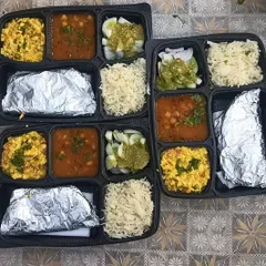 A look at our daily meal packaging, with paneer bhurji, chana masala, fresh salad, fluffy rice, and rotis wrapped in foil to stay warm. Every compartment is filled with care.