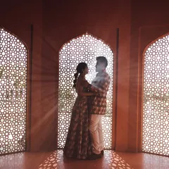 Using the intricate patterns of a traditional jali window to create a stunning silhouette. This artistic approach to a royal setting highlights the beauty of the architecture while keeping the focus on the couple's connection.