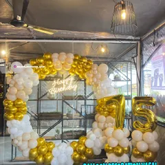 A classic and elegant 75th birthday celebration. The ring backdrop is decorated with white and chrome gold balloons, with large foil numbers.