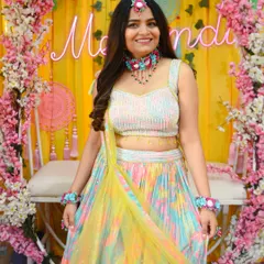 The beautiful bride-to-be at her Mehendi ceremony. Her colorful lehenga and floral jewelry are perfect for the festive occasion.