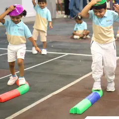 Children participate in a balance beam game, developing coordination and focus while having a great time.