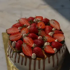 A beautiful strawberry drip cake. This cake is loaded with fresh strawberries and features a delicious caramel drip over smooth vanilla frosting.
