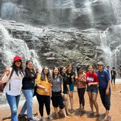 Our group of adventurers posing right at the base of Jhari Falls in Chikmagalur. The spray from the falls and the stunning rock face make for an unforgettable experience.