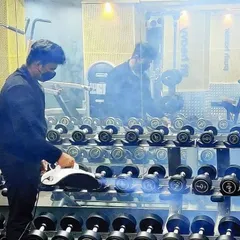 Here I am sanitizing the dumbbell racks. We make sure every piece of equipment, especially high-touch surfaces, is regularly disinfected for your safety.