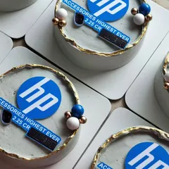 A top-down view of the custom mini cakes created for HP. This image clearly displays the sharp logo work and clean design, reflecting a professional and premium brand image suitable for any corporate occasion.