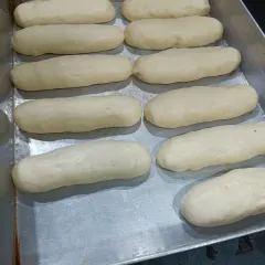 These are my brioche buns, proofing and ready for the oven. A good bake starts with a good dough, and I take my time to make sure it's perfect before it becomes the base for my veggie sausage buns.