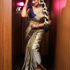 This full-length shot showcases the art of saree draping. The pleats are neat and the pallu falls perfectly, creating a graceful silhouette that enhances the bride's entire look.