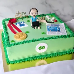 This retirement cake was designed for the editor of Sakal newspaper, celebrating his 60th birthday and career. The design incorporates all his passions: a figurine working on his laptop, an edible newspaper, a marathon medal, and a cricket ball, all set on a field of green buttercream.