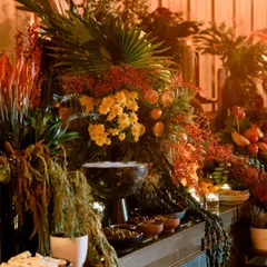 I design grazing tables that are edible landscapes. Here, a cascade of florals, fruits, and foliage merges with curated platters, creating a multi-sensory experience where food becomes part of the art.
