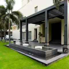 The entrance to this home is enhanced by a linear water feature with bubbling fountains, set against a lush green lawn. This design element adds a sense of arrival and tranquility, welcoming guests with the gentle sound of water.