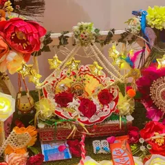 For Janmashtami, I design special jhulas (swings) for Laddu Gopal. This setup includes a decorated swing, star-shaped fairy lights, artificial flowers, and peacock feather details for a festive look.