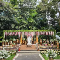 An outdoor puberty ceremony setup that blends with the natural garden surroundings. I created a floral canopy with hanging jasmine and rose garlands, a central white throne, and a beautiful arrangement of sacred props and offerings on a raised platform.