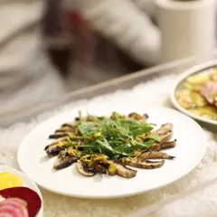 A platter of grilled mushroom salad with arugula, served on a bed of ice to keep it fresh. Our cold buffet selections are crafted with the same care and attention to detail as our hot dishes.