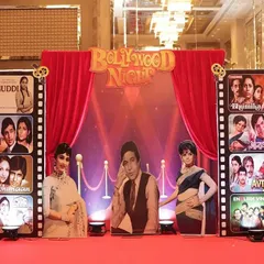 The stage is the heart of any event. This "Bollywood Night" setup featured a red carpet, classic film posters, and life-sized Oscar statues, creating a perfect backdrop for performances and announcements at a corporate awards night.