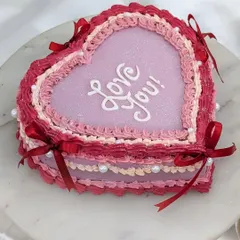 A still shot of our beautiful vintage heart cake. The layered, frilly piping and "Love You!" message make it a perfect cake for anniversaries, Valentine's Day, or just because.