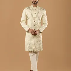 This ornate sherwani, paired with a multi-layered pearl mala, is designed for the groom who seeks a truly royal aesthetic. The intricate embroidery covers the entire garment for a luxurious finish.