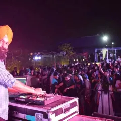 A shot of me at my console, facing a sea of happy faces at a private party. My goal is simple: keep the dance floor packed and the smiles wide. This is what I live for.