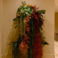 A view of the installation from the side, showing how it cascades and drapes over the console table. My designs are never static; I build them with a sense of movement, allowing the foliage and flowers to flow naturally and interact with the furniture and space around them.