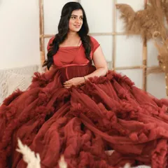This stunning ruffled red gown makes for a truly glamorous maternity photo. The bright, bohemian inspired studio setup adds warmth and texture to the portrait.