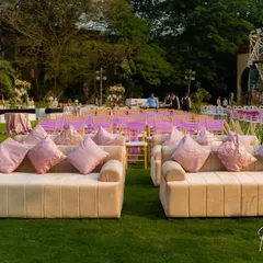Comfortable and stylish lounge seating was provided for guests to relax and socialize. These plush sofas with pink cushions offered a comfortable alternative to the main seating area, adding a touch of informal elegance to the outdoor gala.