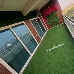 I can turn any urban balcony into a green oasis. This high-angle shot shows a complete transformation with wall-to-wall artificial turf, providing a maintenance-free lawn with a stunning city view.
