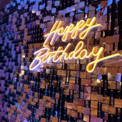 There's nothing like the sparkle of a shimmer wall. Here is a close-up of a custom neon sign against a gold sequin backdrop, creating a warm, inviting glow that makes any celebration feel extra special. This is a fantastic option for an anniversary or milestone birthday party.