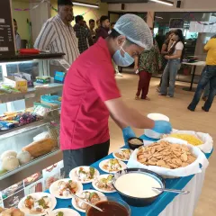 We bring the fun to your event with interactive live food stations. Here, our chef is preparing fresh dahi papdi chaat at a corporate party, allowing guests to customize their snacks just the way they like them. It’s a great way to add energy and engagement to any celebration.