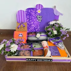 A birthday breakfast platter designed to delight. This hamper includes a delicious spread of South Indian favorites like idli and vada, along with sandwiches and jalebi, all in a lovely purple theme with fresh flowers.