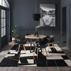 A great rug can be the centerpiece of a room. In this dramatic dining room setup, I used bold, graphic art and monochromatic tones to make the geometric rug the undeniable hero. This is an example of how I style a scene to ensure the product commands attention.