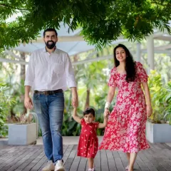 A happy family strolls hand in hand through a lush Bangalore park. We believe the most magical family portraits happen during these natural, unposed moments of togetherness.